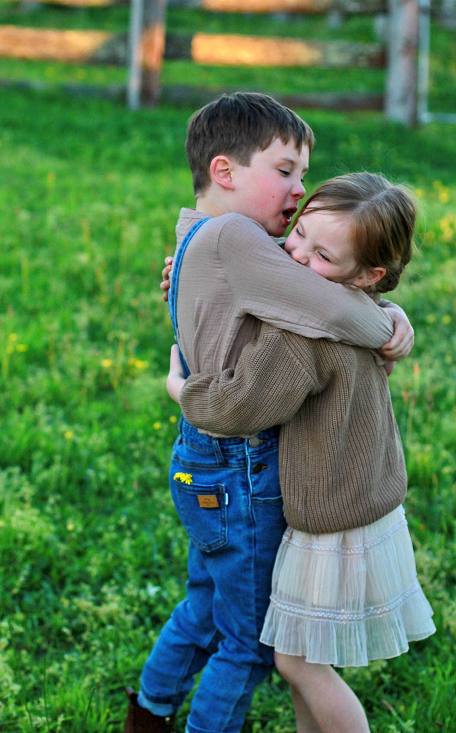 Brother and sister hugging each other during an outdoor family session