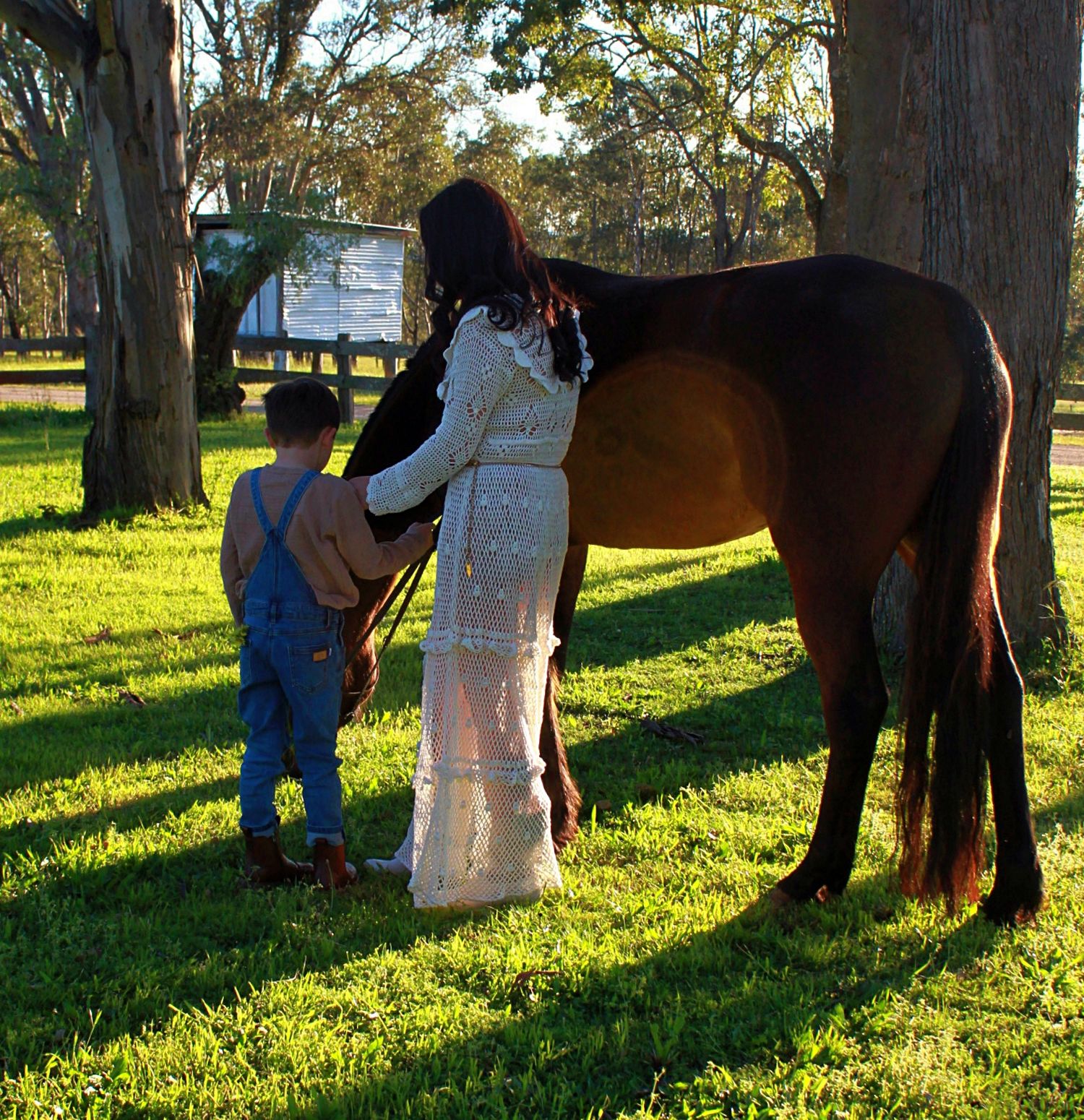 Mother and son gently interacting with a horse outdoors during a family session