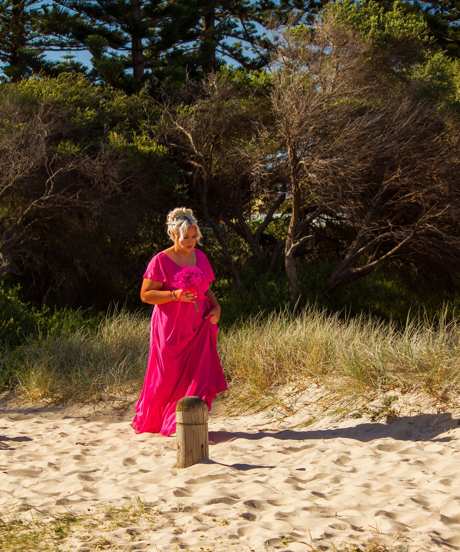 Bridesmaid walking down the aisle at a beach wedding ceremony, elegant moment before the bride’s entrance.