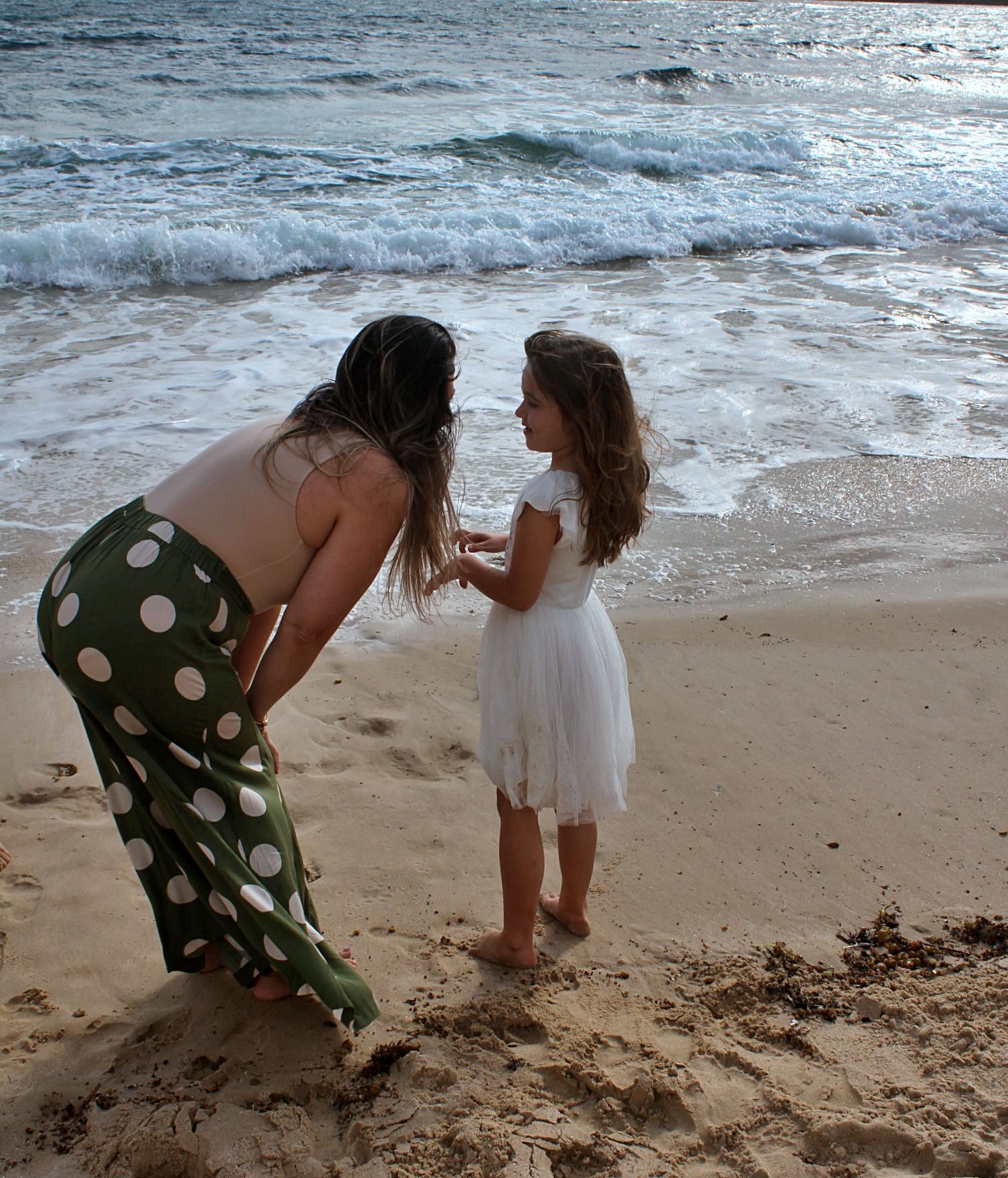 Candid moment between mum and daughter during a family session on the beach in the Illawarra, full of warmth and love.