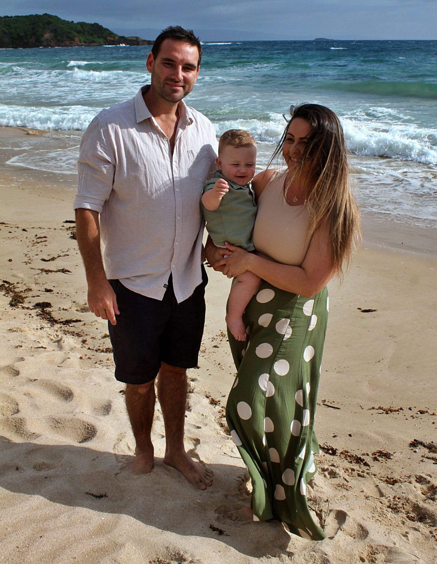 A natural family moment of mum and dad with their son on the beach in the Illawarra.
