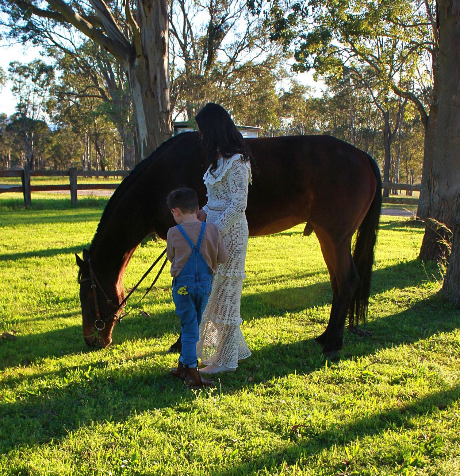 Mother and son gently interacting with a horse outdoors during a family session