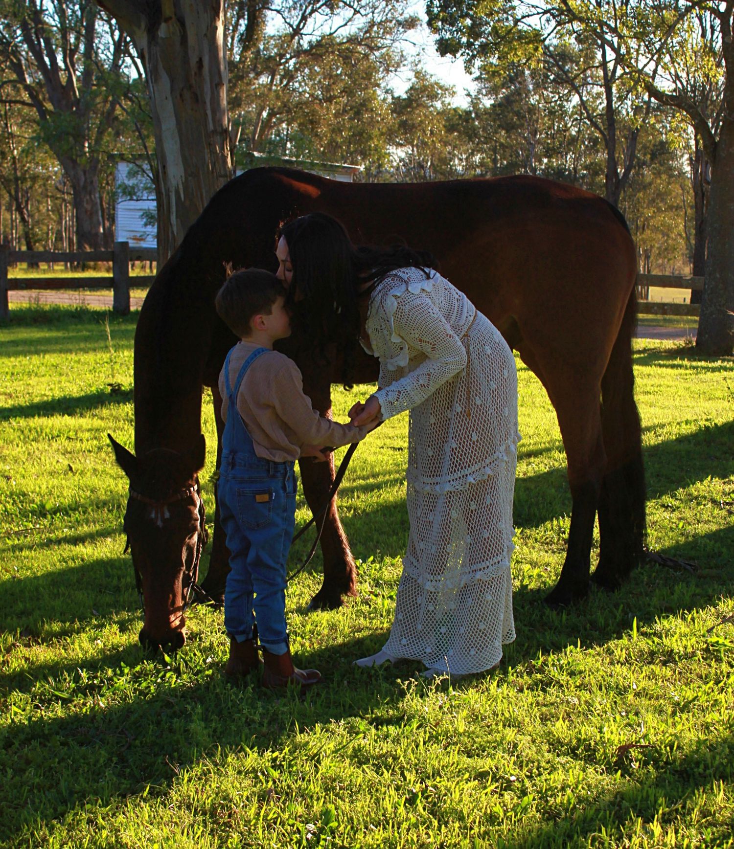 Mother and son gently interacting with a horse outdoors during a family session