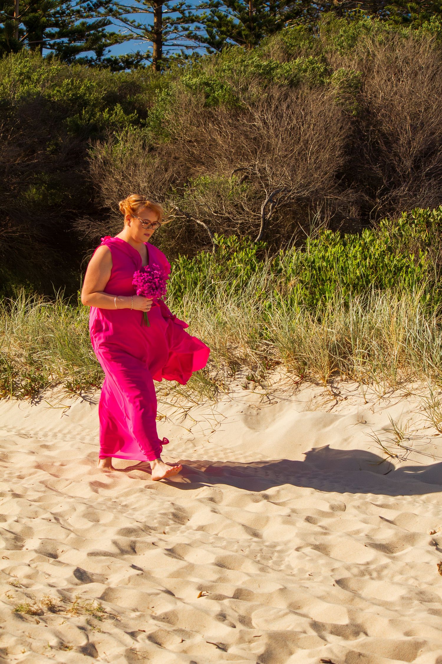 Bridesmaid walking down the aisle at a beach wedding ceremony, elegant moment before the bride’s entrance.