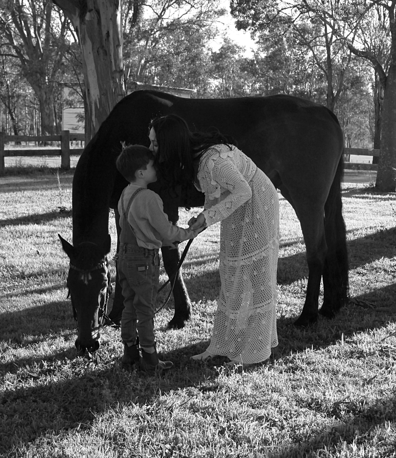 Mother and son gently interacting with a horse outdoors during a family session