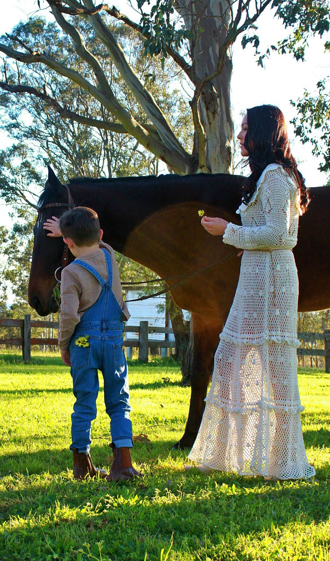 Mother and son gently interacting with a horse outdoors during a family session