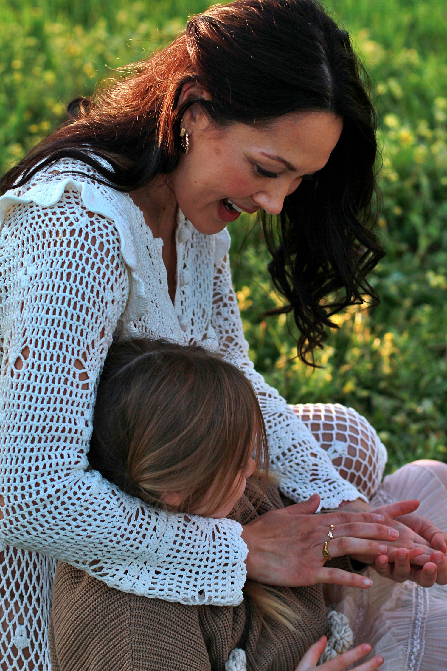 Close up of mum gently playing with daughter’s hand during a family session