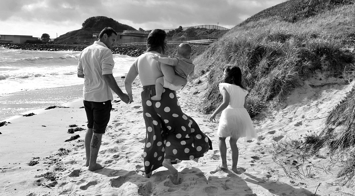 Candid family portraits by the sea in the Illawarra, documenting genuine moments and timeless beachside connection.