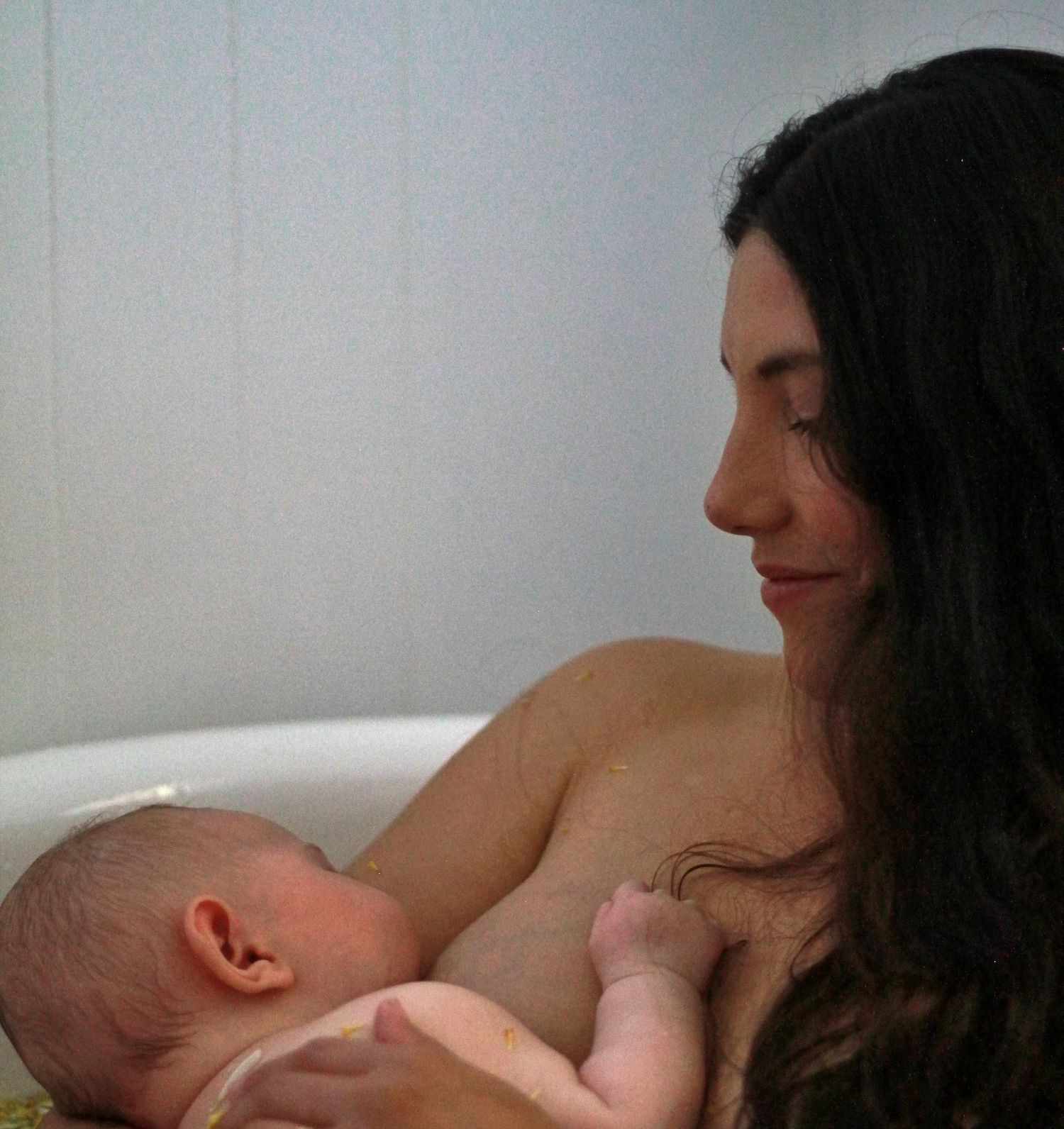 Mother breastfeeding her baby during a natural lifestyle motherhood session at home by A Lasting Impression Photography.