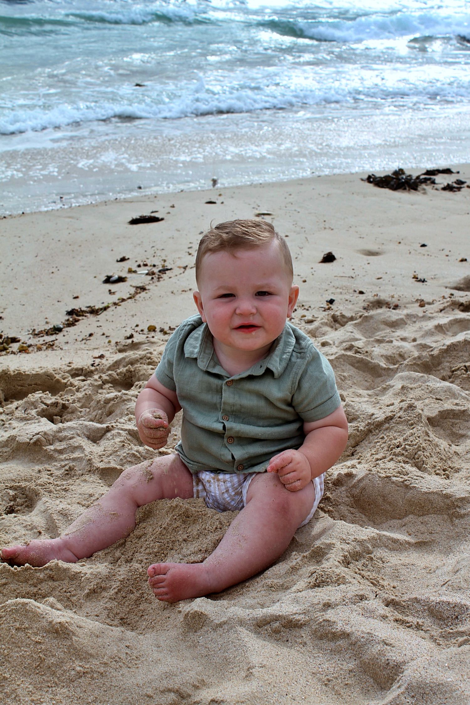 A candid portrait of a son playing in the sand on the beach in the Illawarra, full of curiosity and fun.