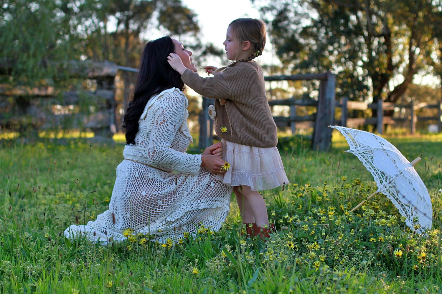 Sweet moment of daughter decorating mum’s hair with flowers during a family session