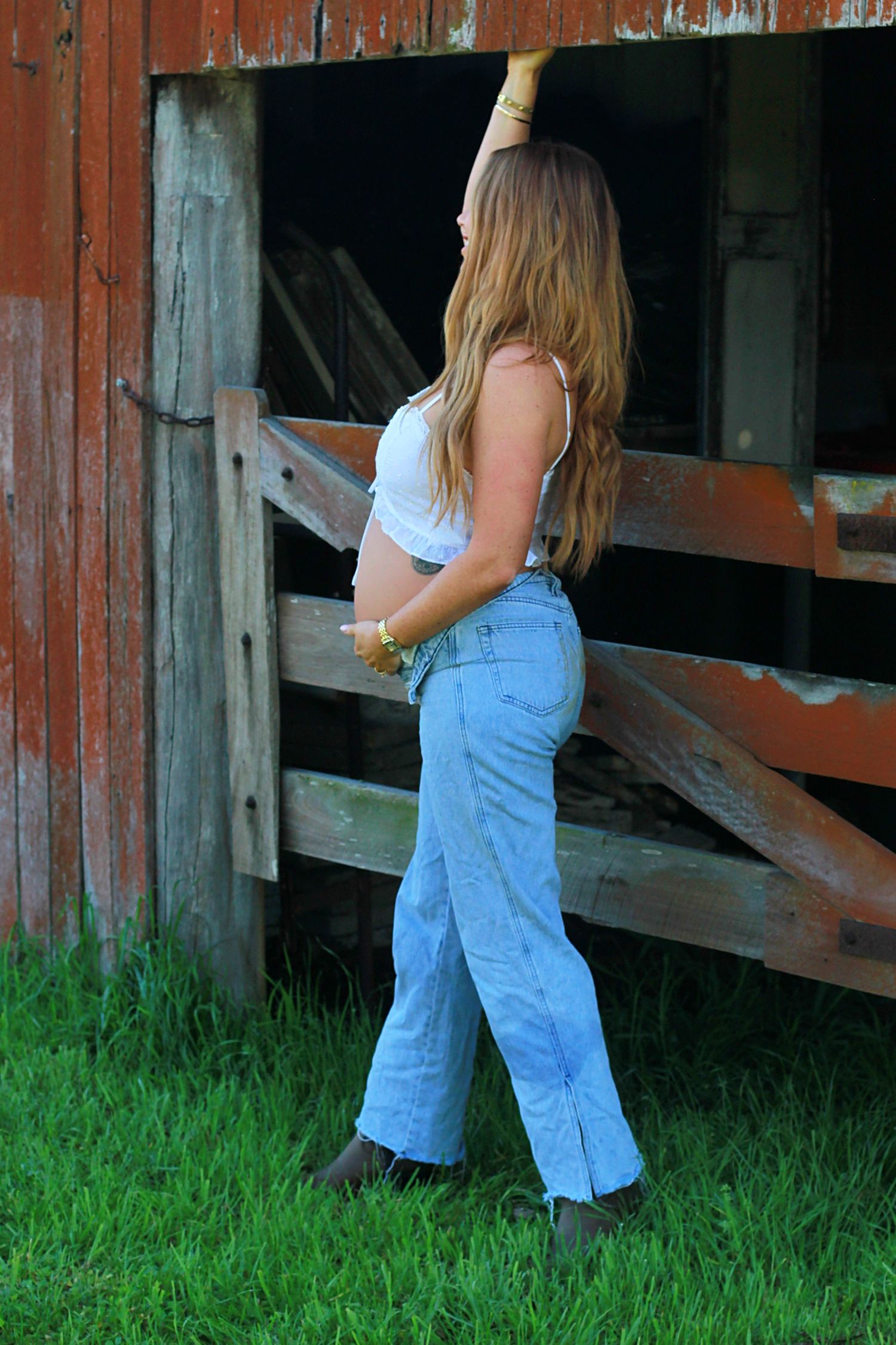 Expectant mother enjoying a natural maternity photoshoot by a barn by A Lasting Impression Photography.