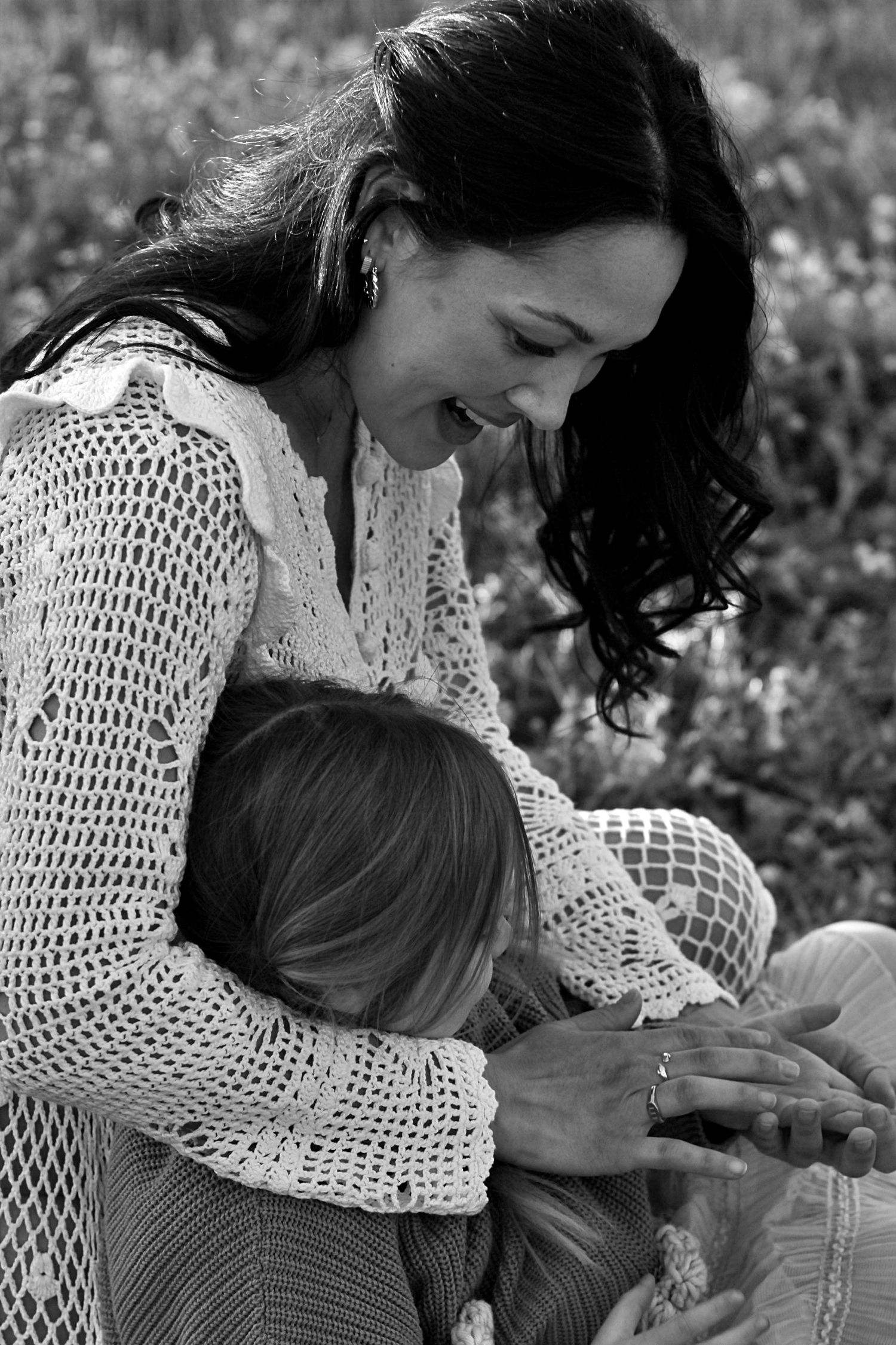 Close up of mum gently playing with daughter’s hand during a family session