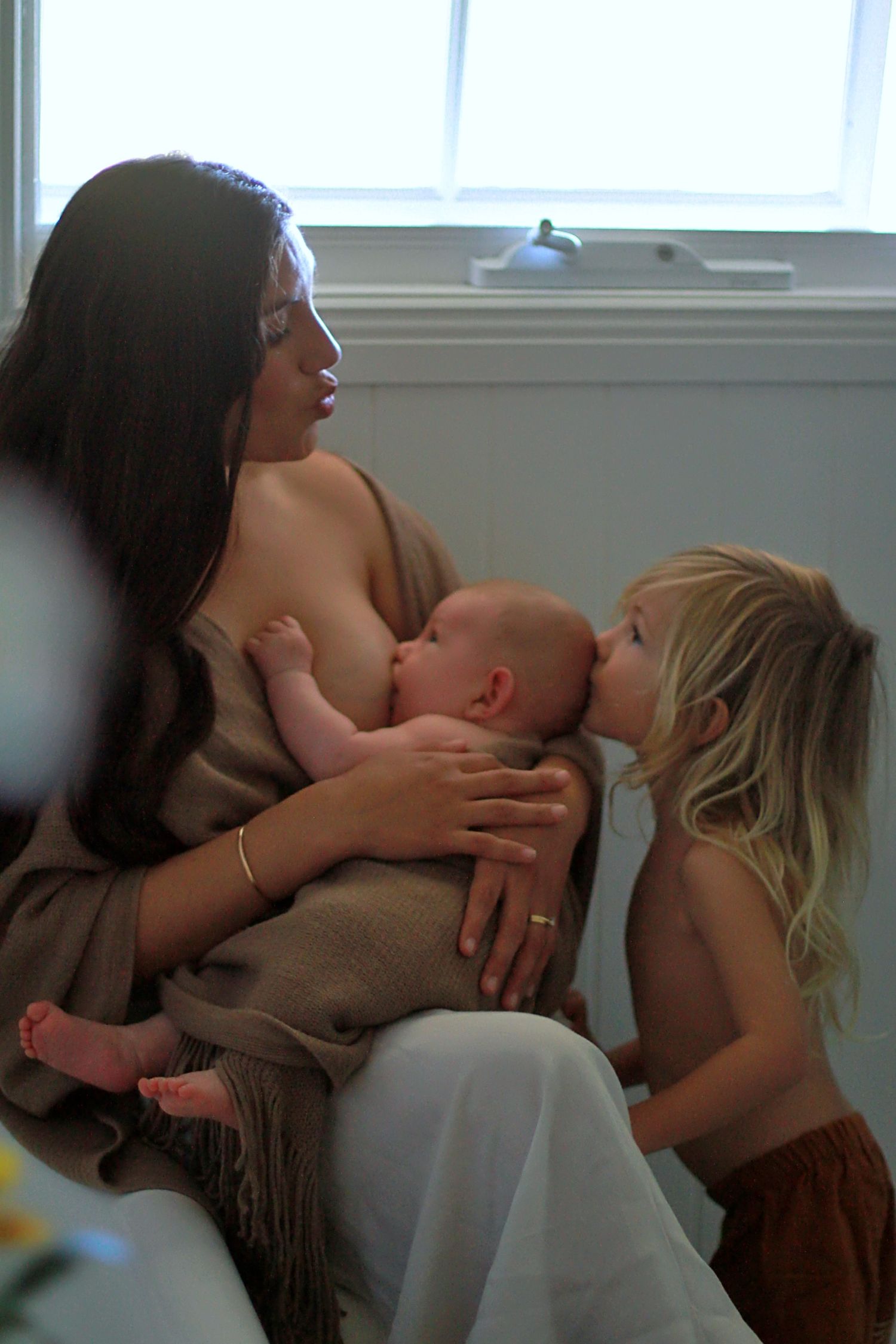 Candid moment of sibling love in a lifestyle motherhood photoshoot by A Lasting Impression Photography.