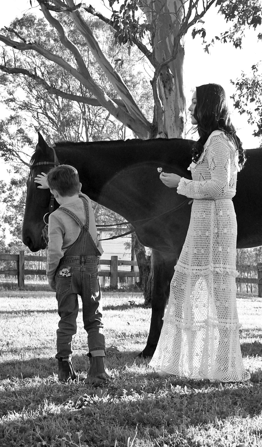 Mother and son gently interacting with a horse outdoors during a family session