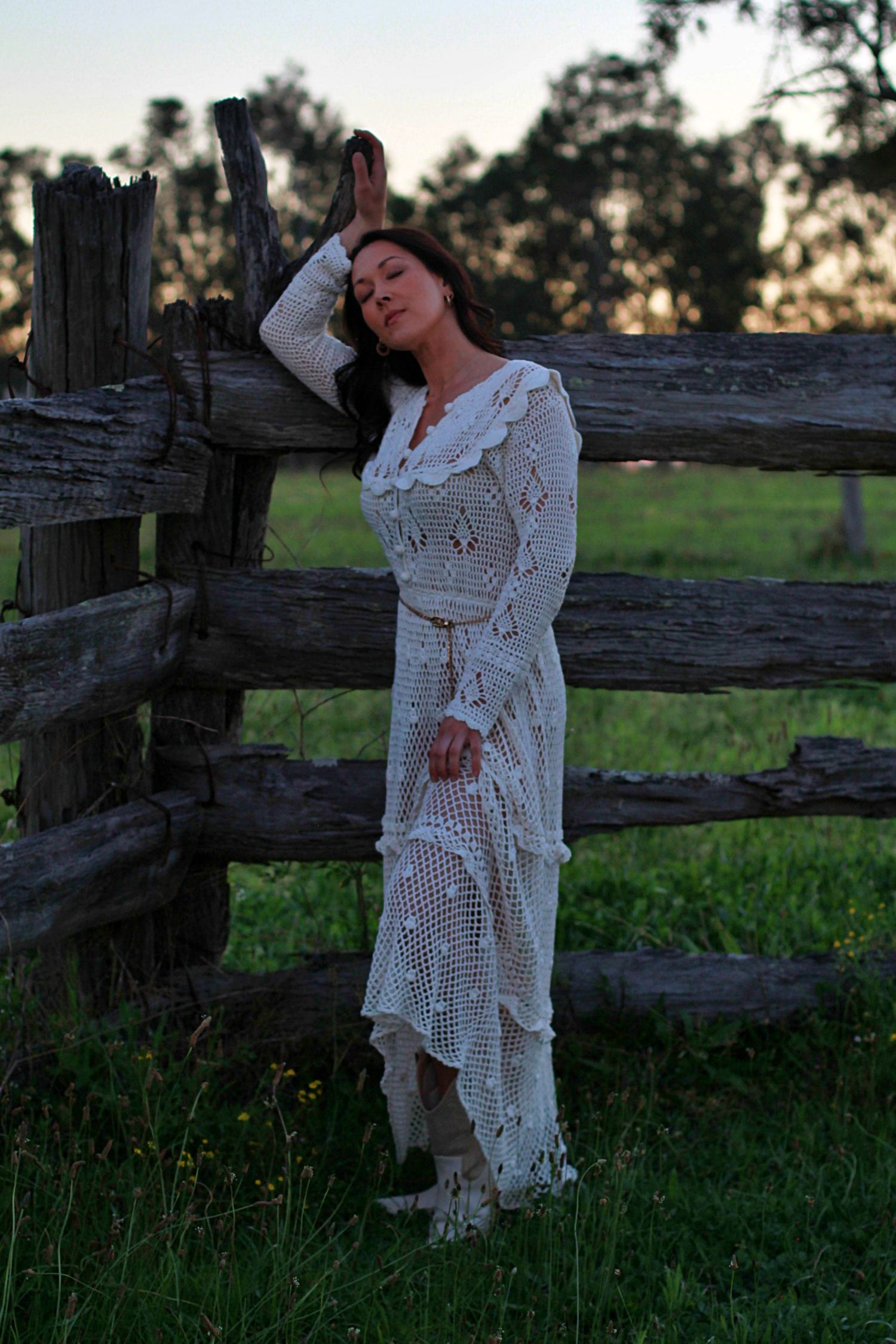 Elegant outdoor portrait of a woman leaning on a fence