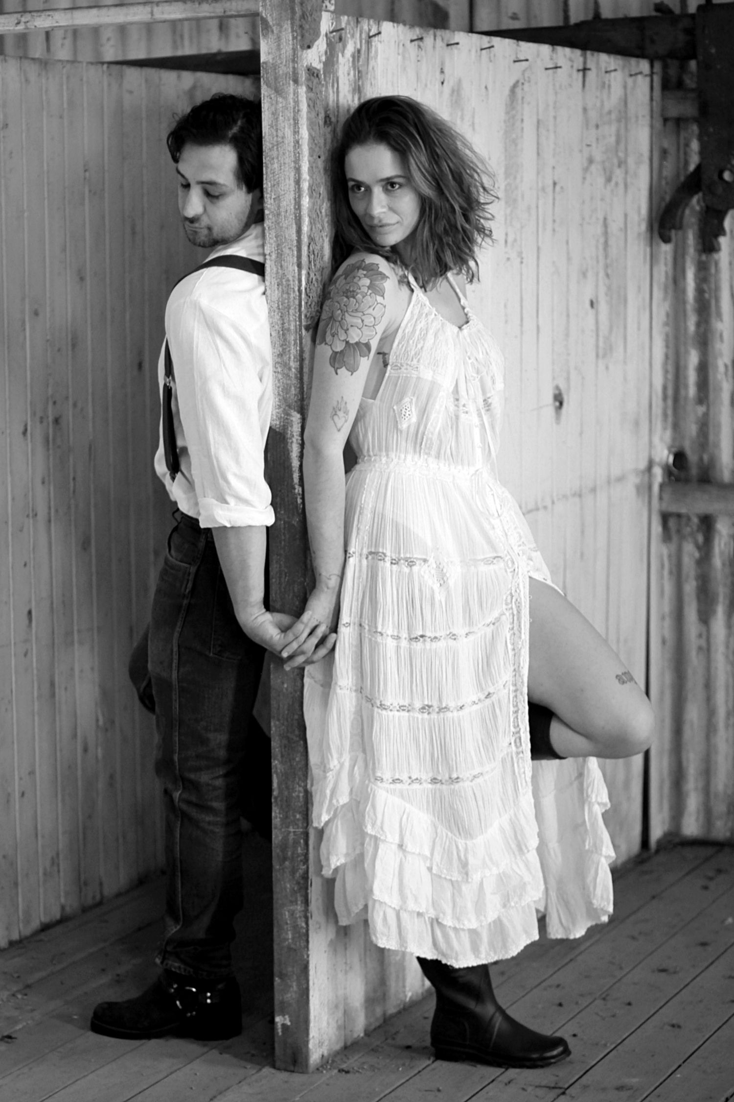 Country engagement session featuring a couple at a barn in black and white