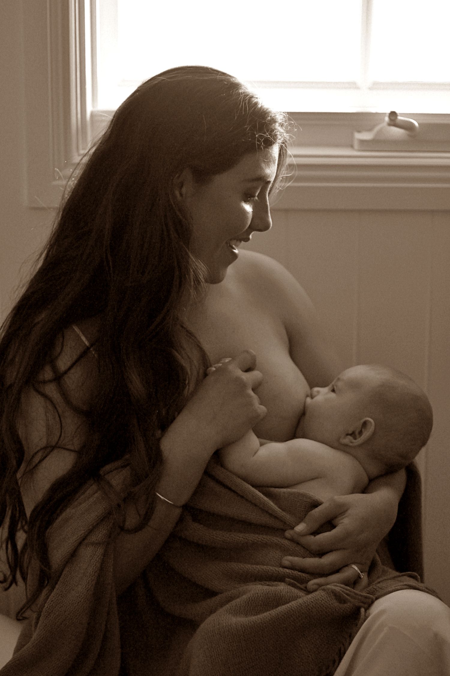 Mother breastfeeding her baby during a natural lifestyle motherhood session at home by A Lasting Impression Photography.