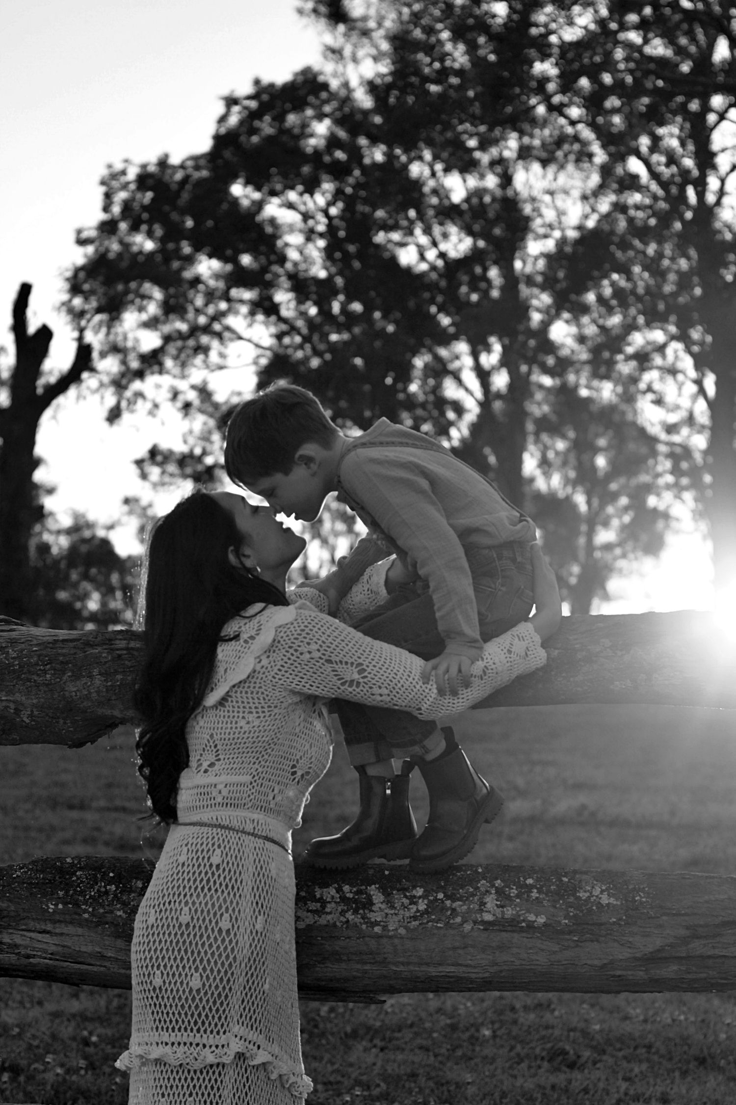 Mum leaning in to kiss her son’s nose during a family session