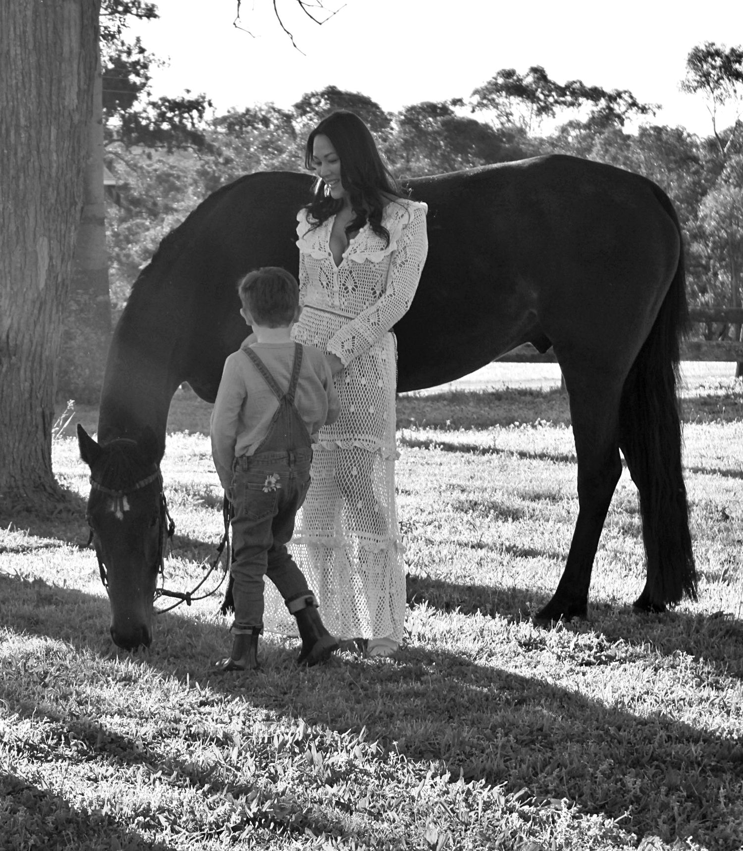 Mother and son gently interacting with a horse outdoors during a family session