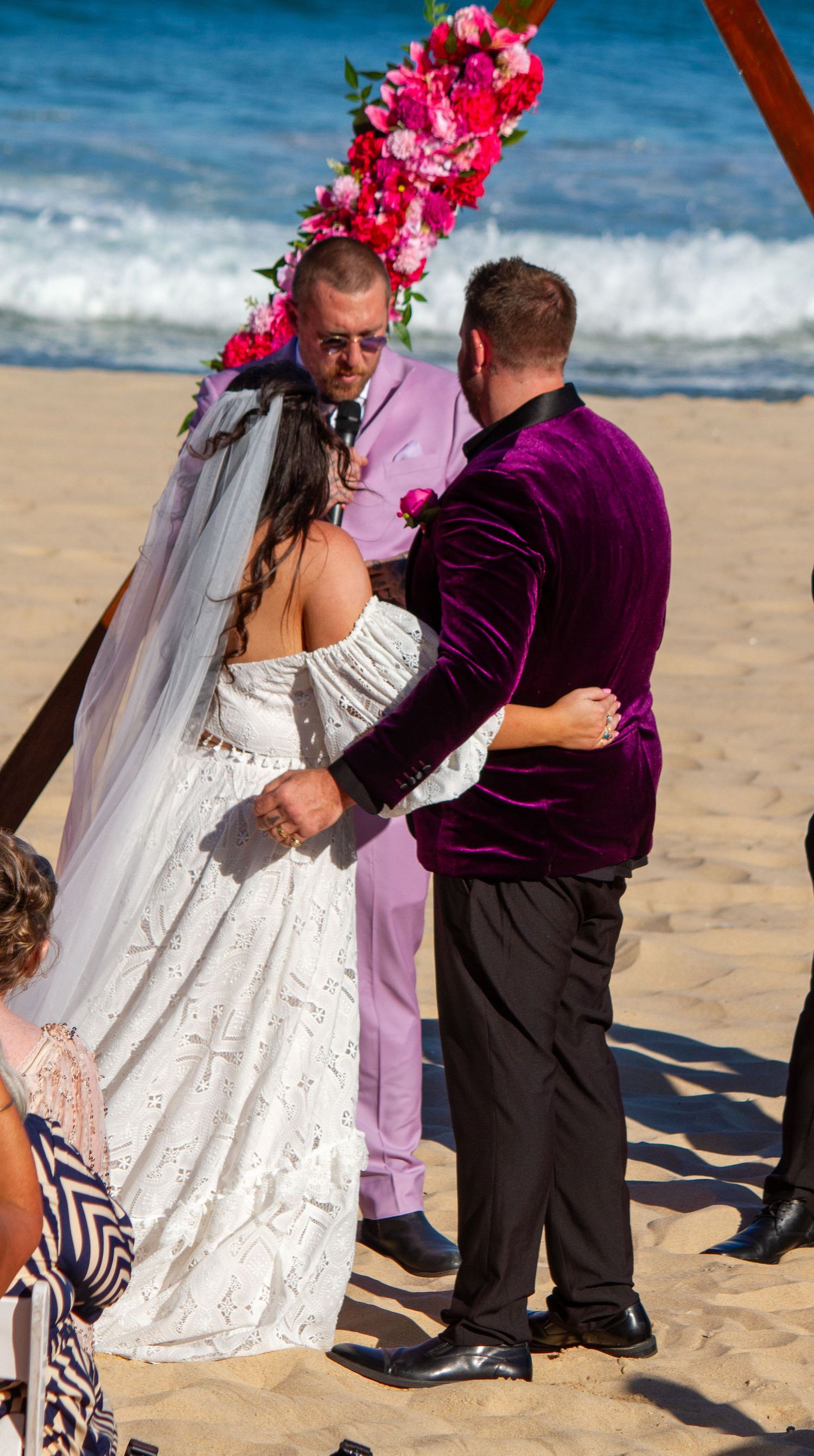 Couple hugging during a beach wedding ceremony at Wollongong, with the ocean and sandy shoreline in the background