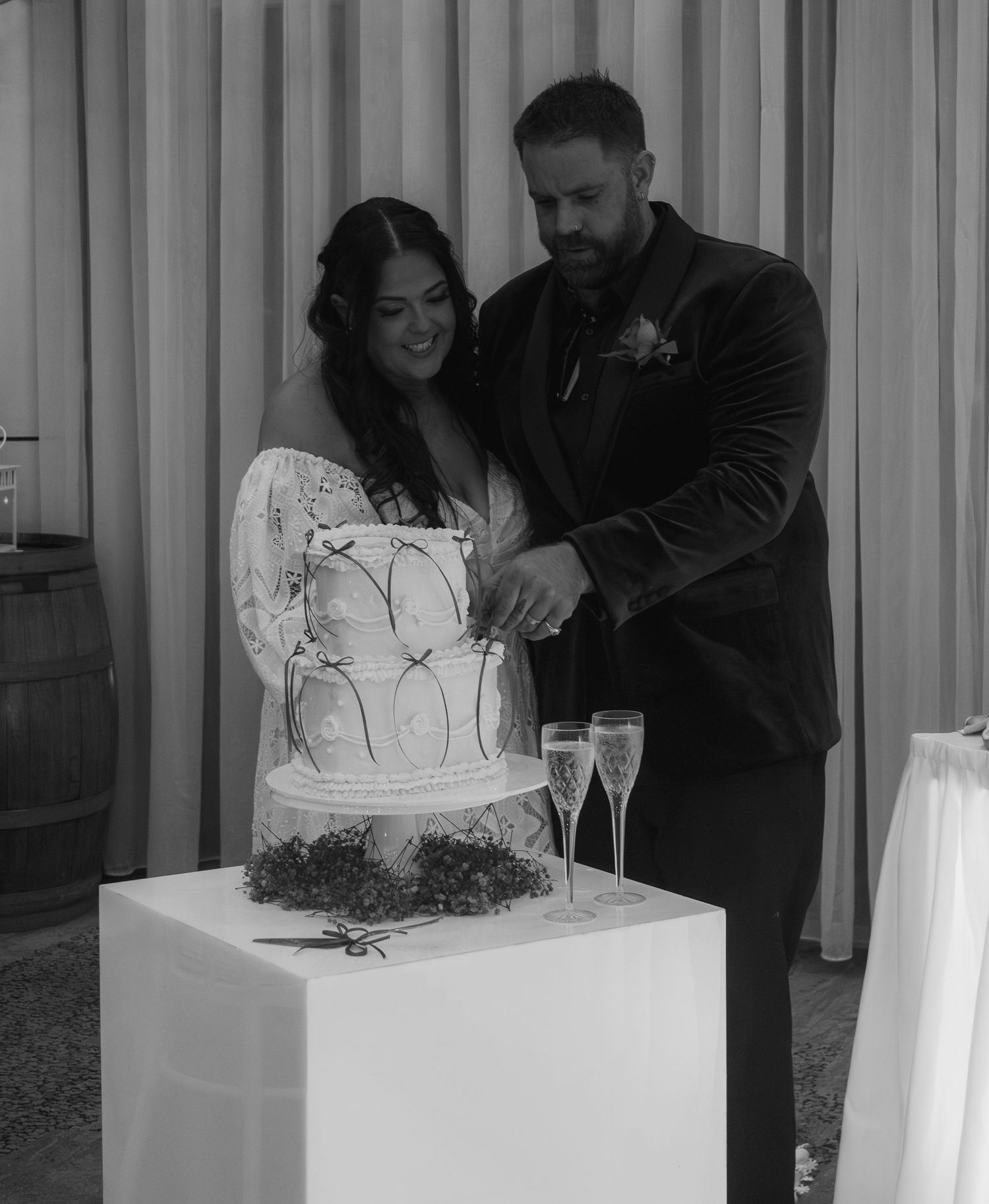 Bride and groom cutting their wedding cake together during the reception celebration.