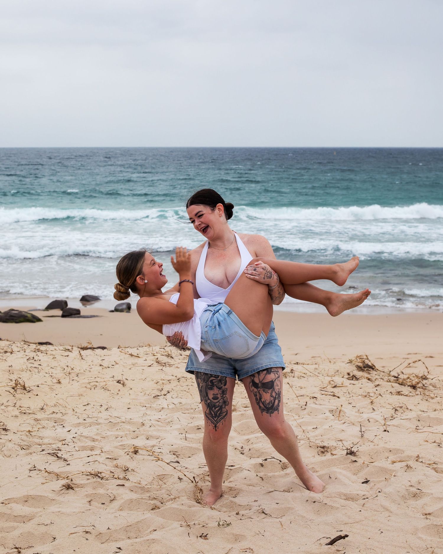 Goofy mother-daughter moment laughing together at the beach during a motherhood session taken by A Lasting Impression Photography.