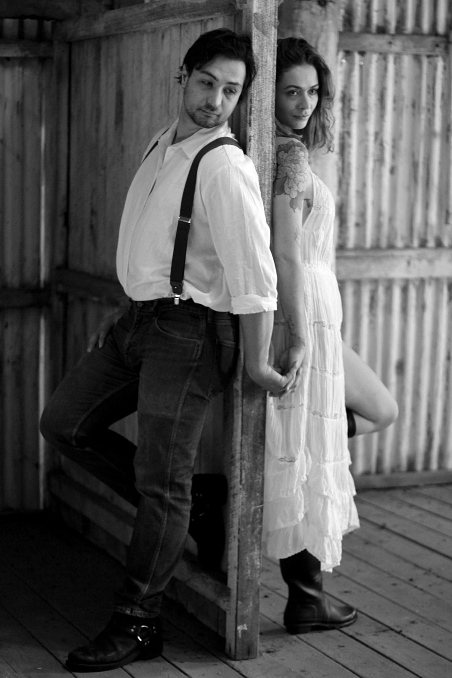 Country engagement session featuring a couple at a barn in black and white