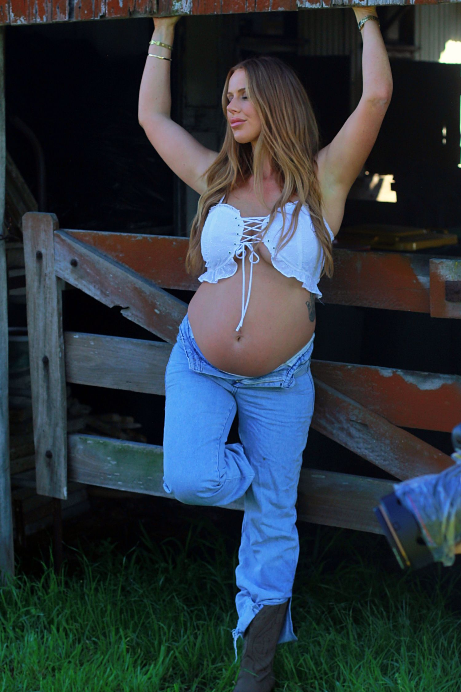 Expectant mother enjoying a natural maternity photoshoot by a barn by A Lasting Impression Photography.