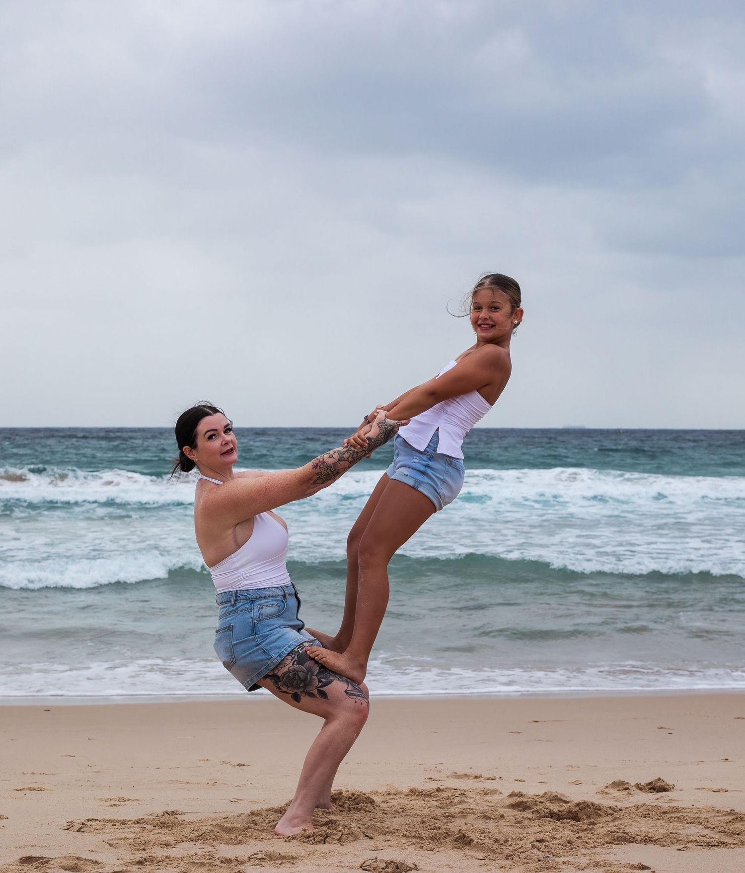 Strength and joy captured as mum holds daughter on her thighs in outdoor session during motherhood session taken by A Lasting Impression.