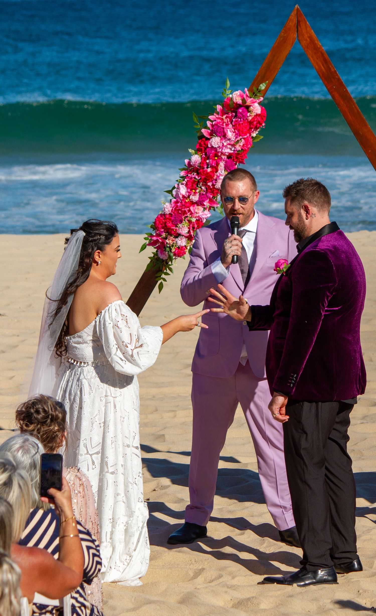 Bride and groom playing rock, paper, scissors to see who reads their vows first at an Illawarra beach wedding.