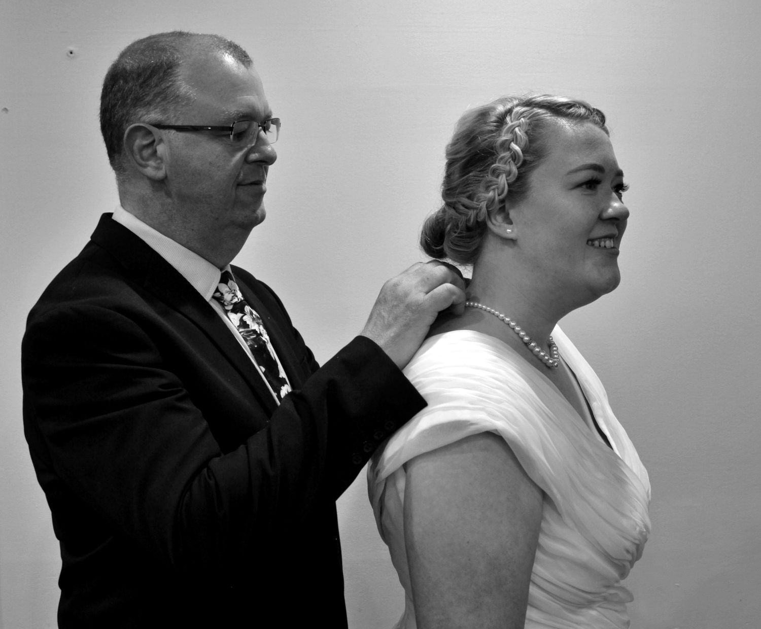 Black and white portrait of father putting necklace on bride during micro wedding in the Illawarra