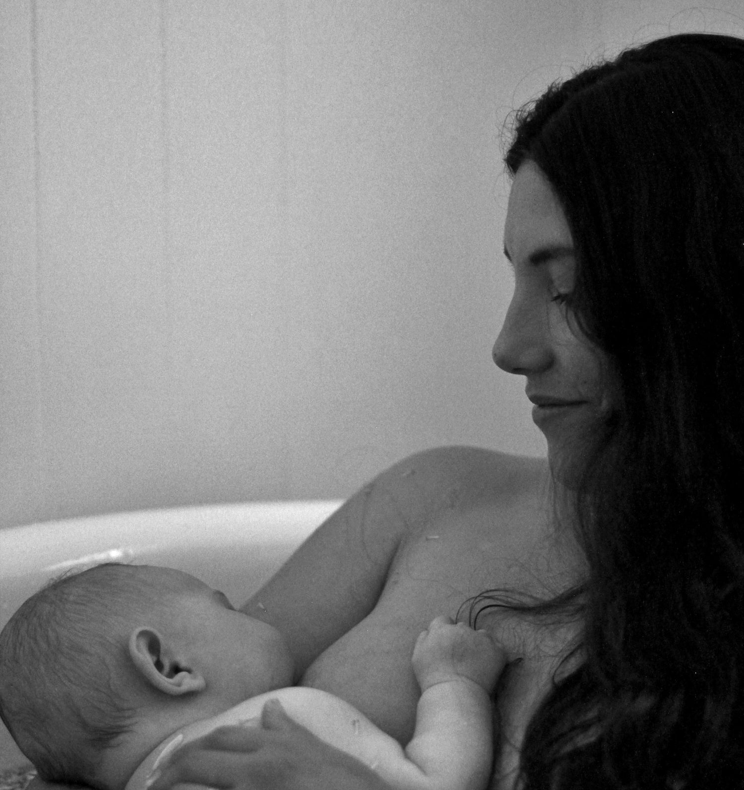 Mother breastfeeding her baby during a natural lifestyle motherhood session at home by A Lasting Impression Photography.
