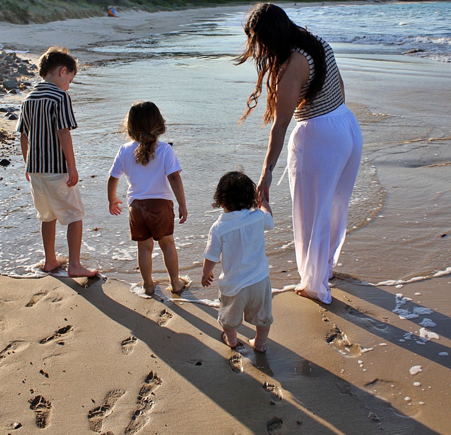 Mum walking with her three children along the beautiful beaches of the Illawarra, capturing authentic family moments, connection, and joy.