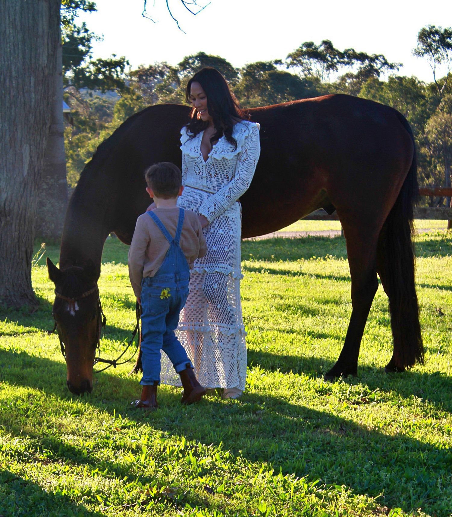 Mother and son gently interacting with a horse outdoors during a family session