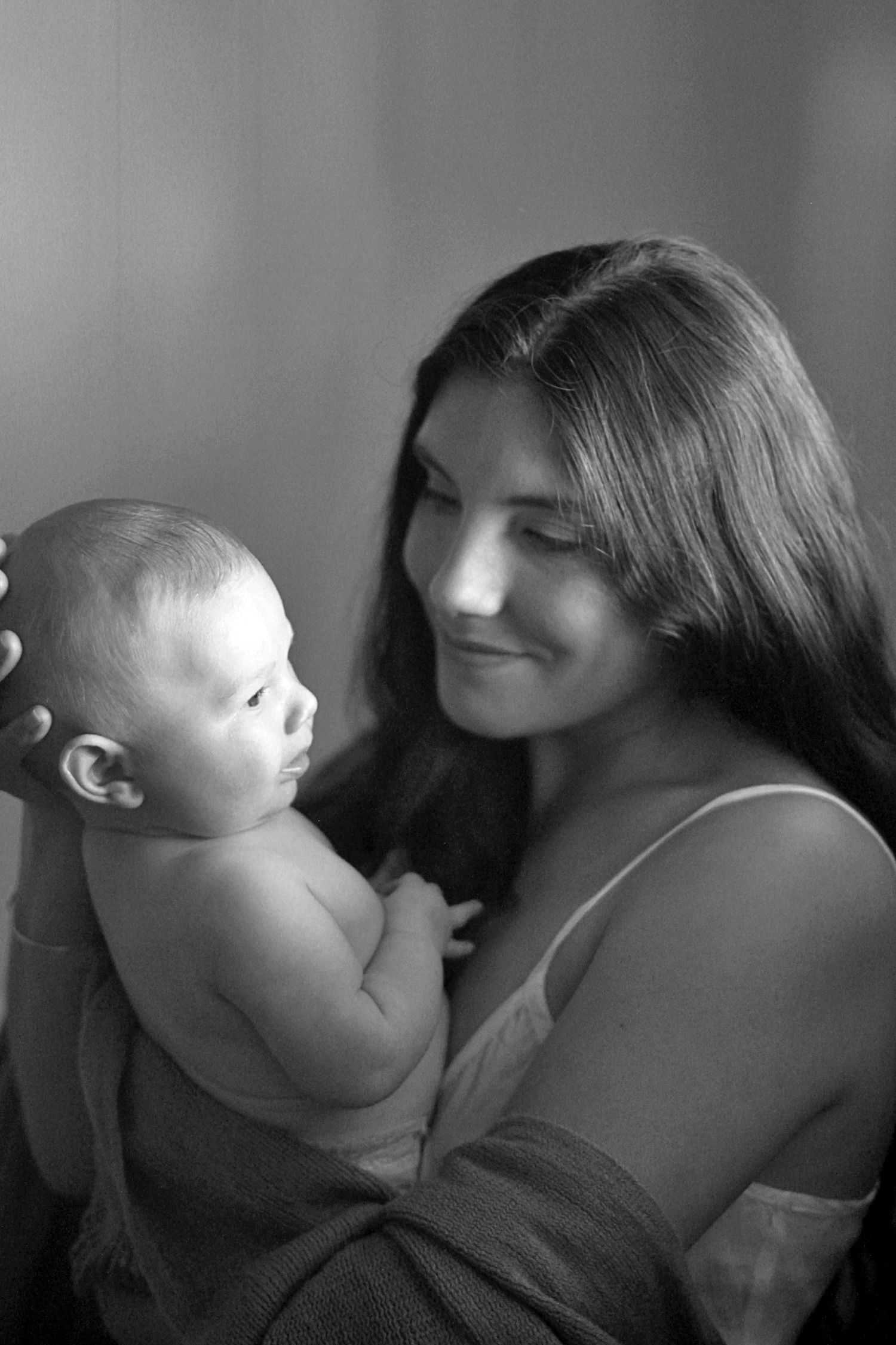 Intimate motherhood moment of a mum cuddling her baby at home by A Lasting Impression Photography.