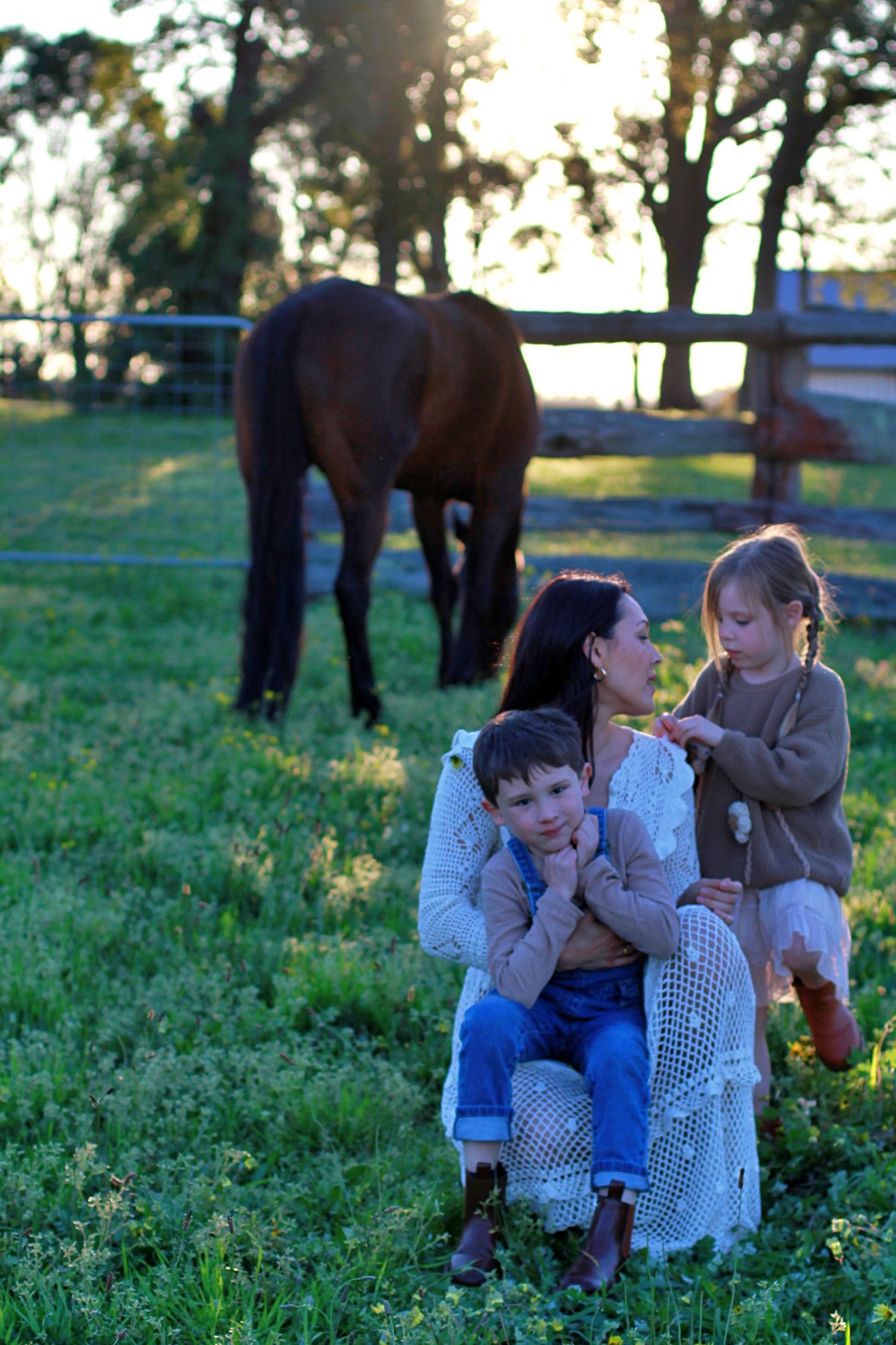 Relaxed family photo of mum and children sitting together outdoors during a family session