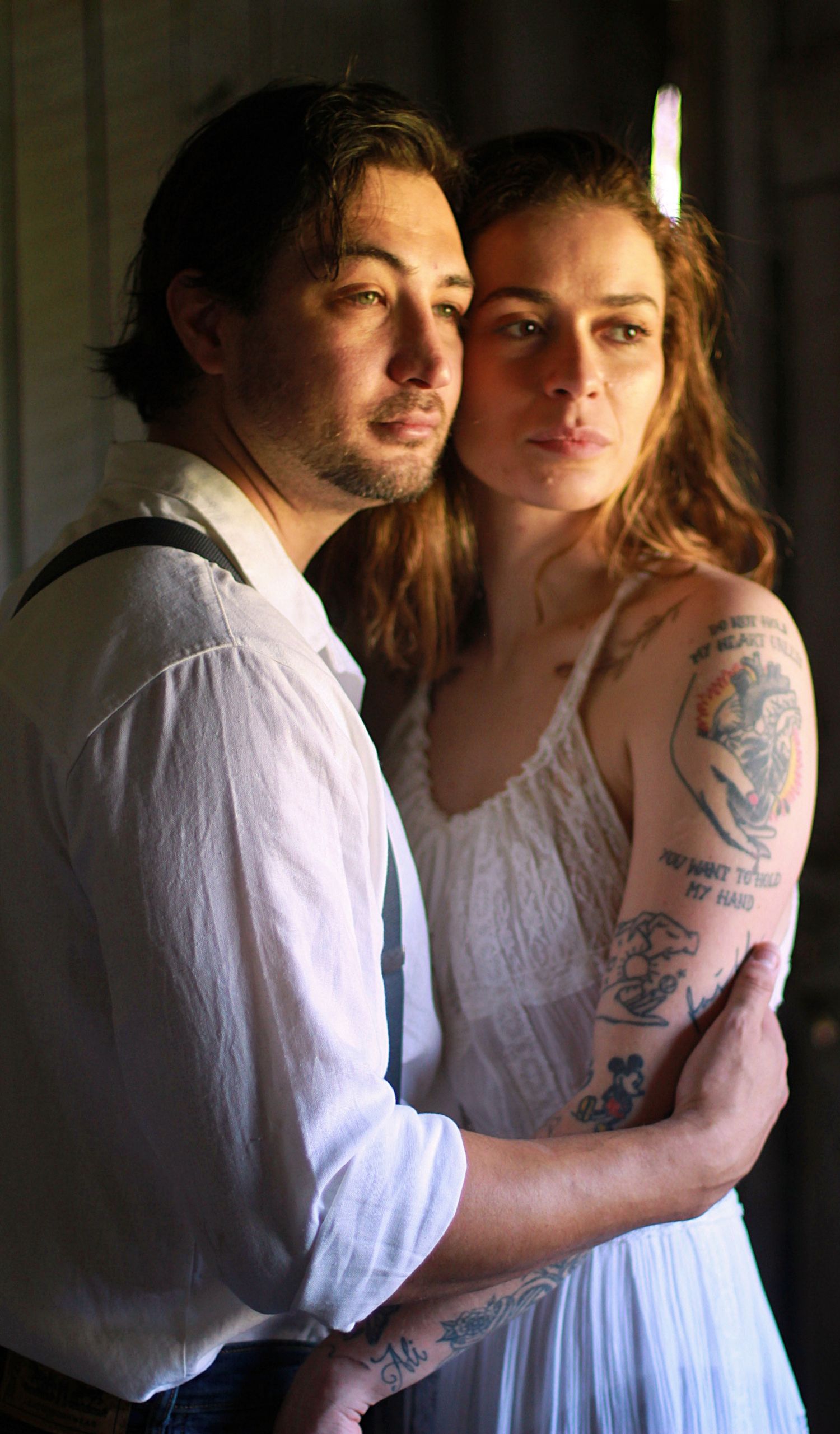 Couples faces gently touching, looking off into the distance as the golden sun illuminates their faces, capturing intimate, natural moments.