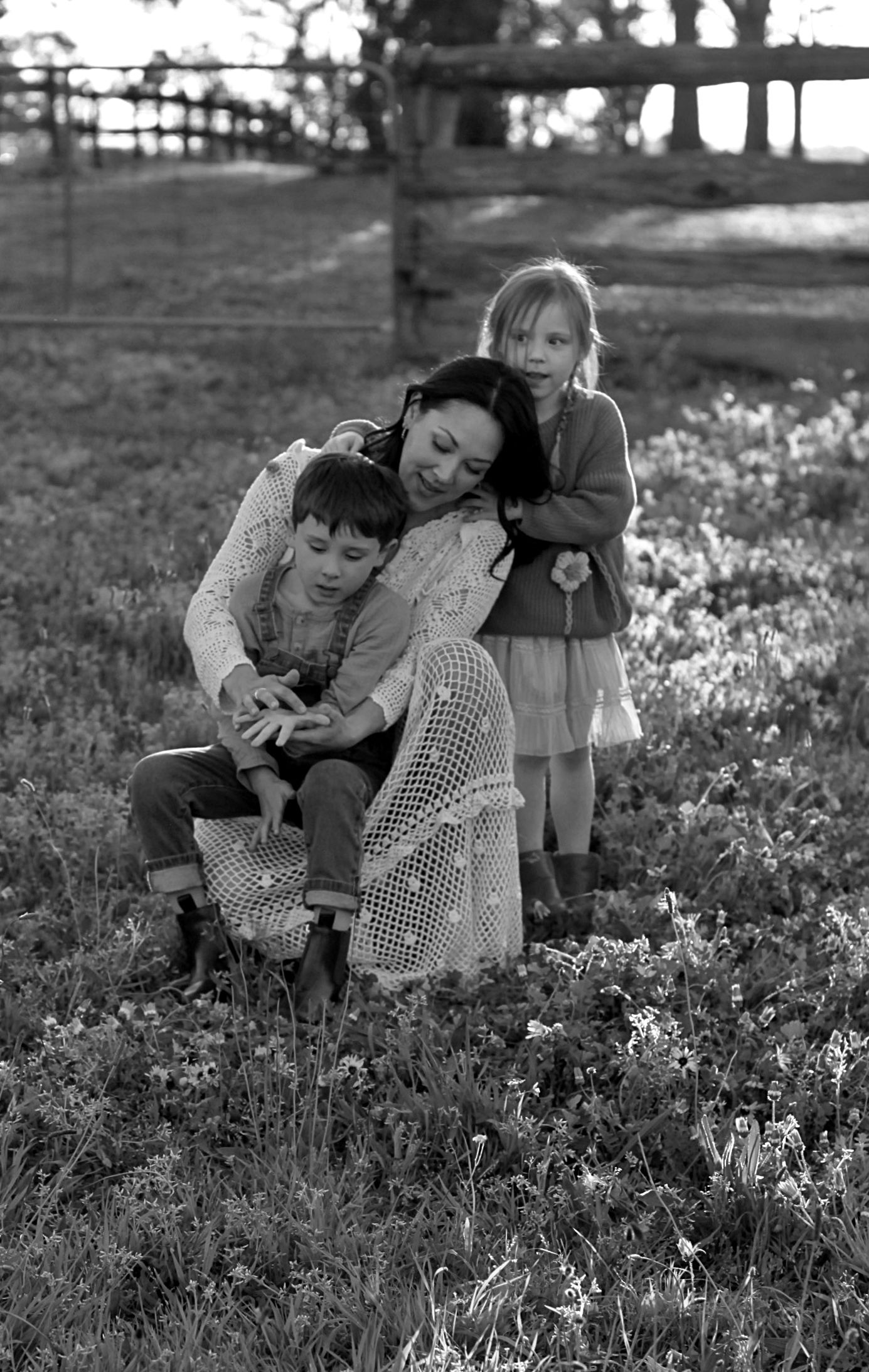 Relaxed family photo of mum and children sitting together outdoors during a family session