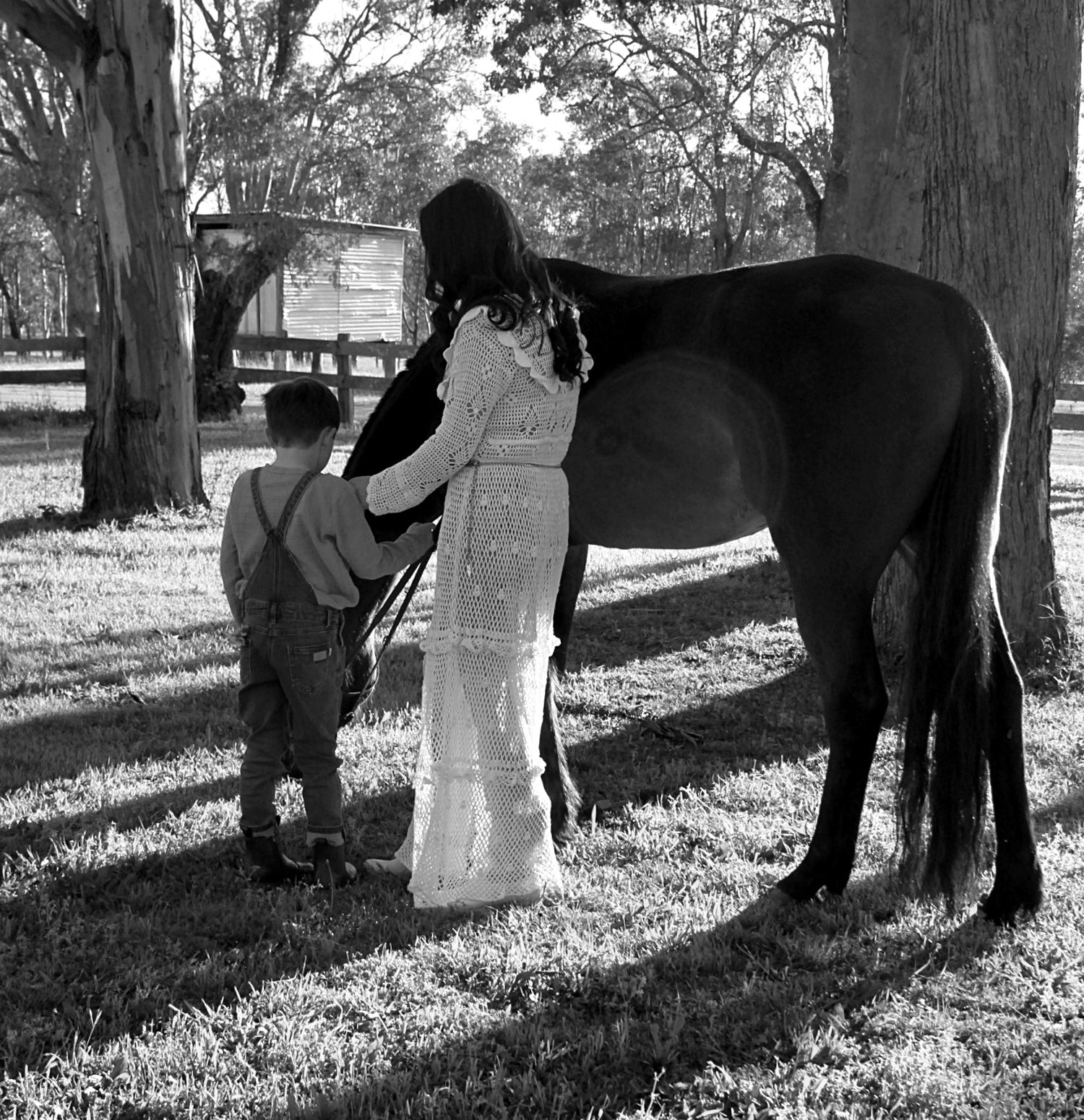 Mother and son gently interacting with a horse outdoors during a family session