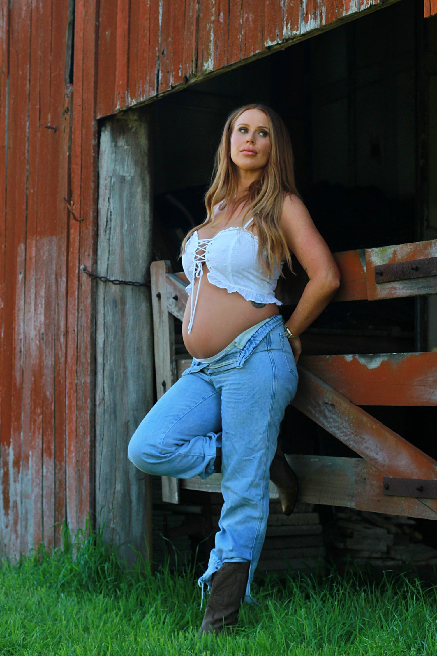 Expectant mother enjoying a natural maternity photoshoot by a barn by A Lasting Impression Photography.