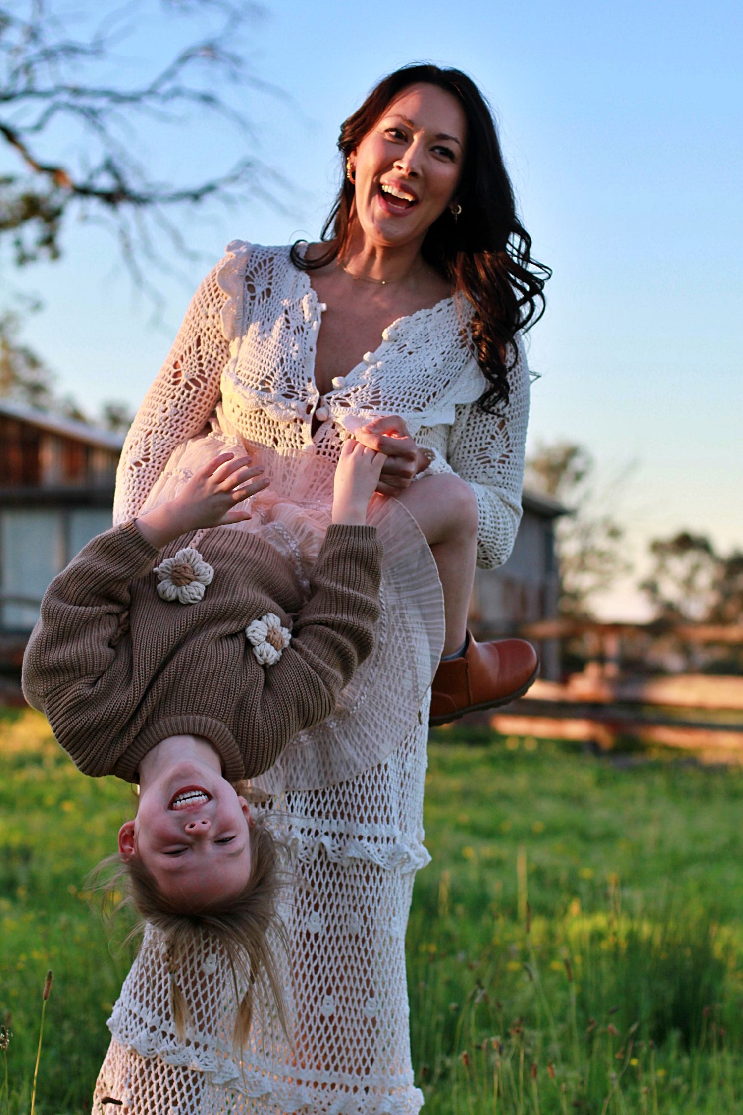 Daughter and mum playing a game in the field during a family session