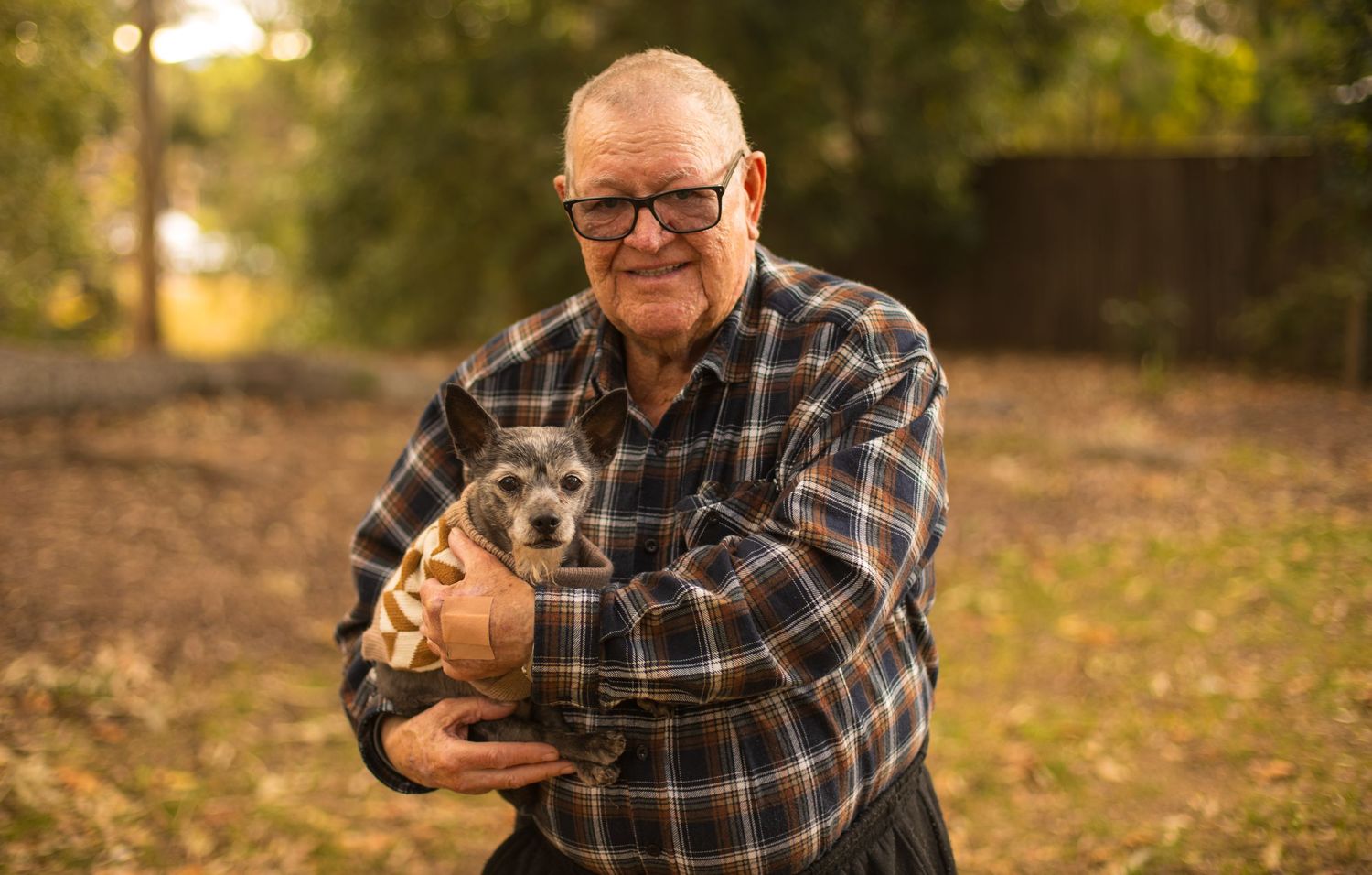 Grandad cuddling the family puppo during a relaxed outdoor family photography session.