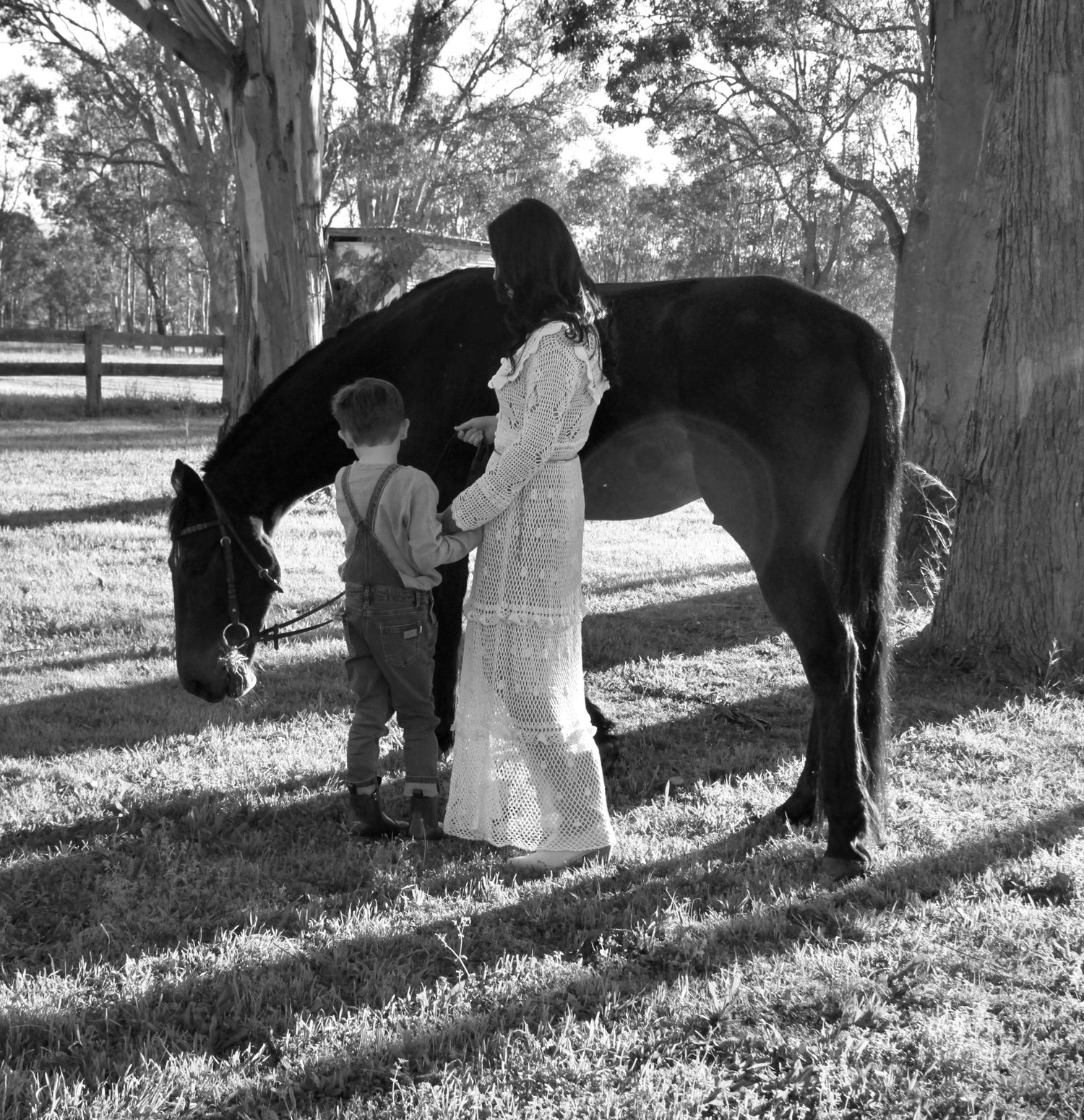 Mother and son gently interacting with a horse outdoors during a family session