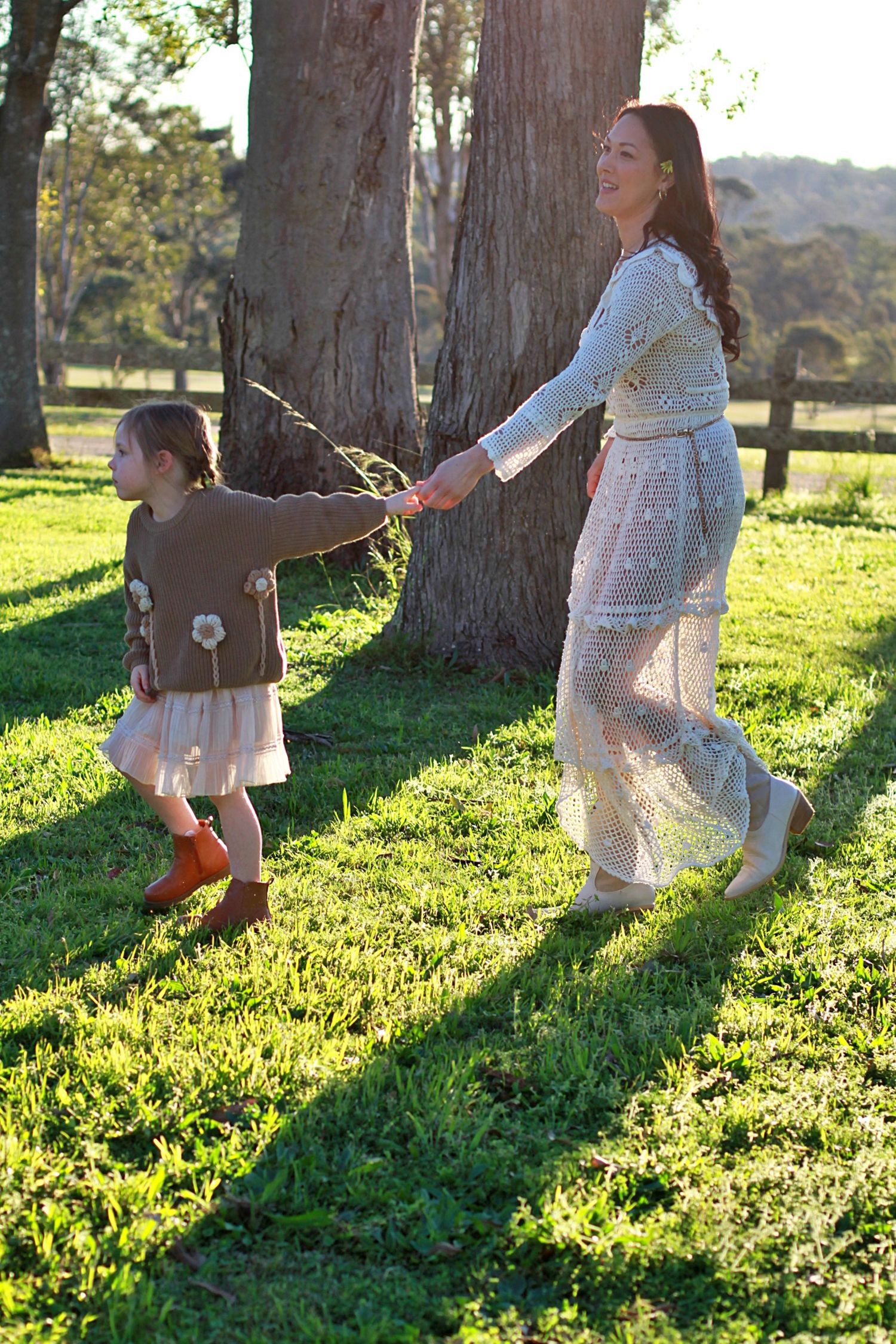 Mum and daughter walking away together in a country setting during a family session