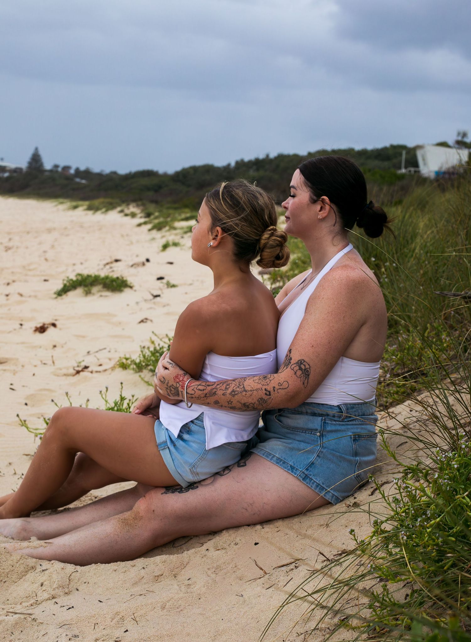 Sweet mother-daughter embrace on grassy headlands during a motherhood session taken by A Lasting Impression Photography.