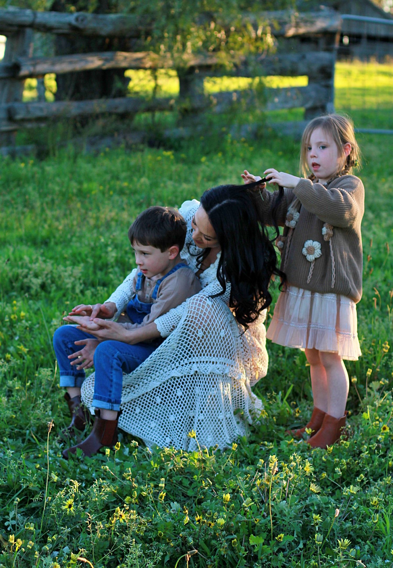 Relaxed family photo of mum and children sitting together outdoors during a family session