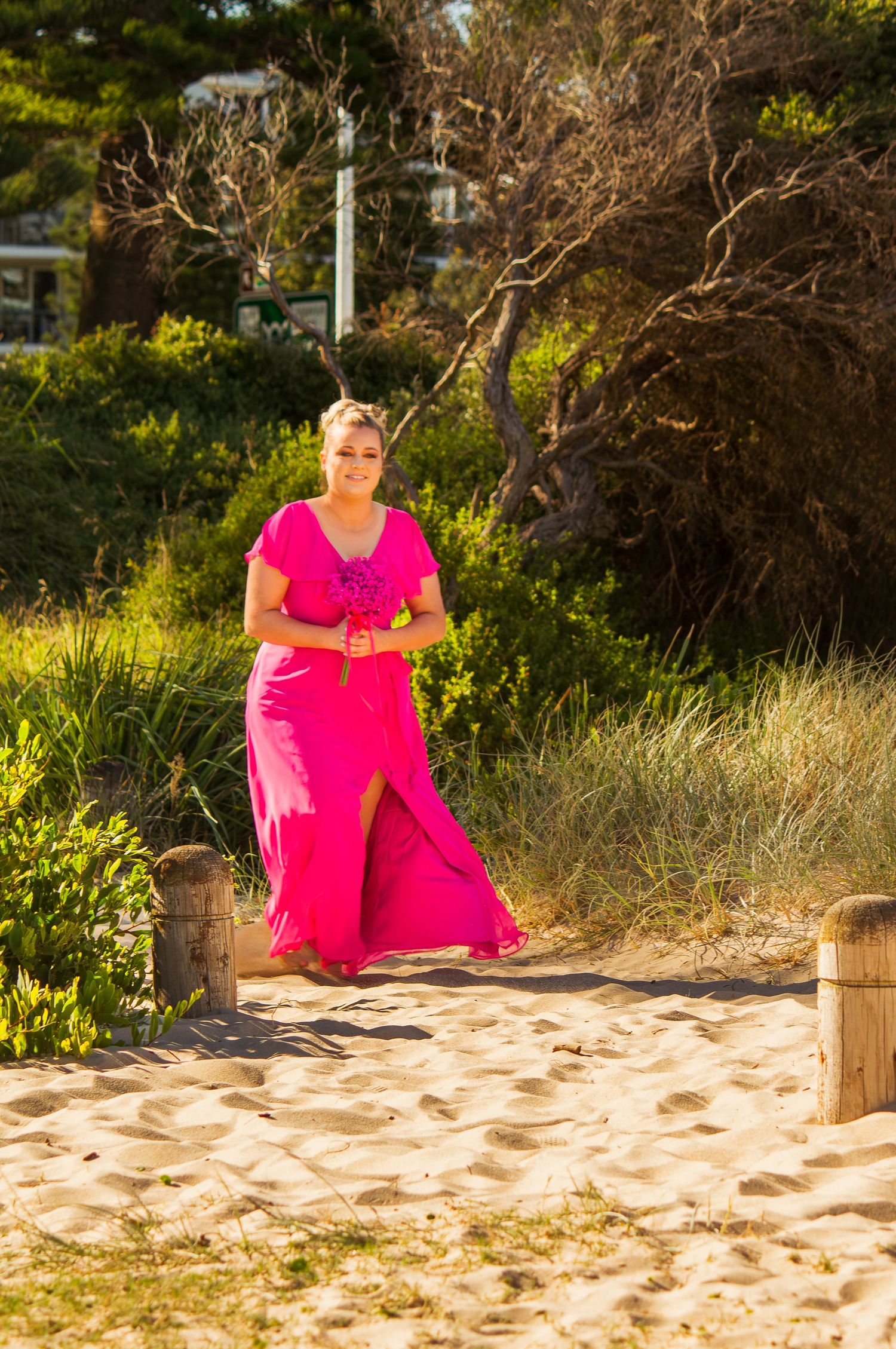 Bridesmaid walking down the aisle at a beach wedding ceremony, elegant moment before the bride’s entrance.