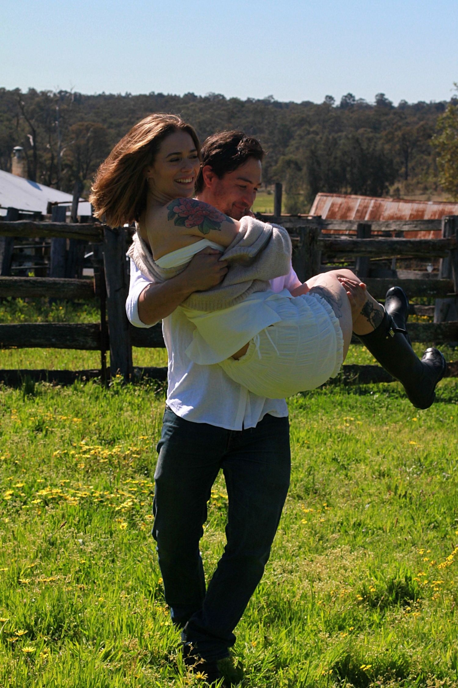 Engagement session in a grassy field during golden hour light