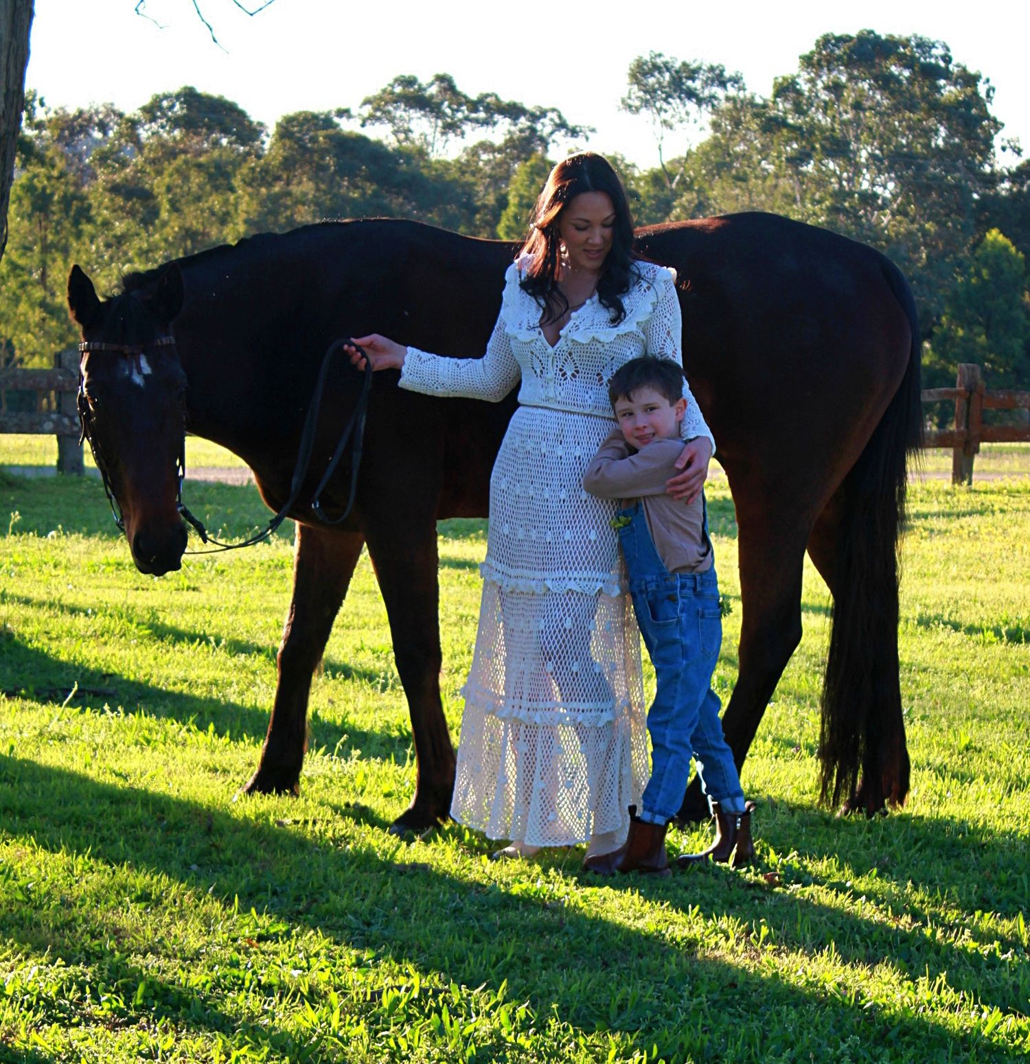 Mother and son gently interacting with a horse outdoors during a family session